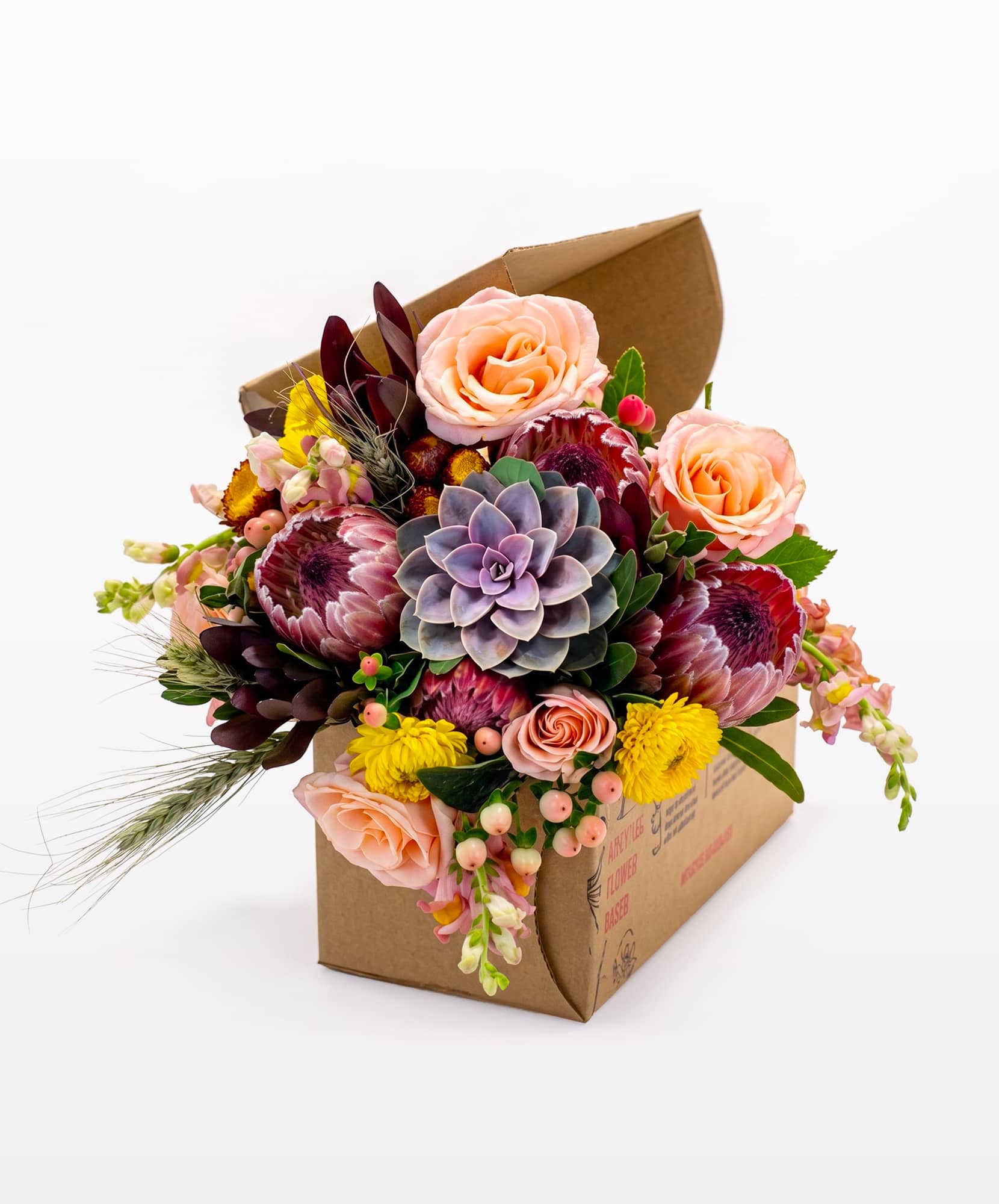 Vibrant floral arrangement with roses, succulents, and assorted blooms in a gift box.