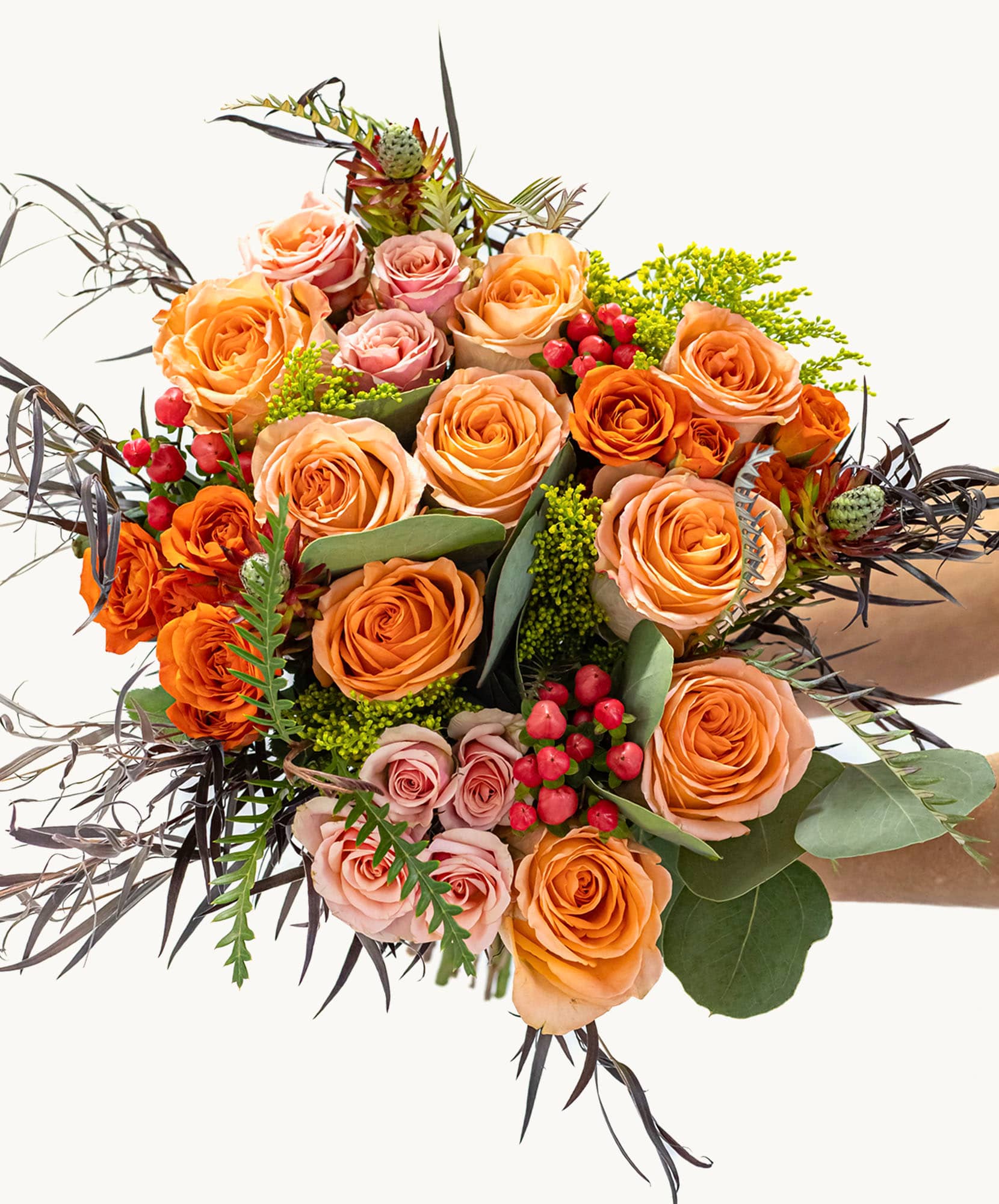 Vibrant bouquet of oranges and pinks with lush greenery, perfect for any celebration.